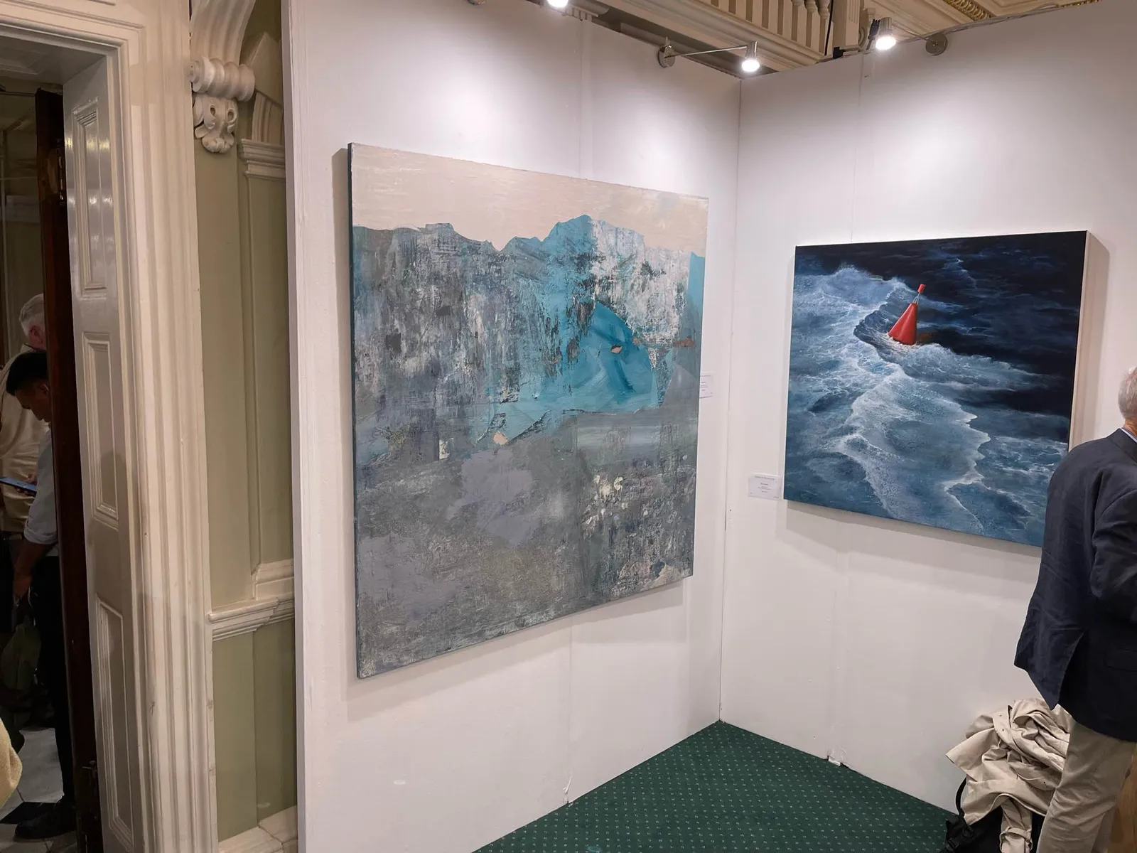 Blue Deviation Issue installed in its exhibition corner at the London Art Biennale 2023, next to a seascape painting by another selected artist