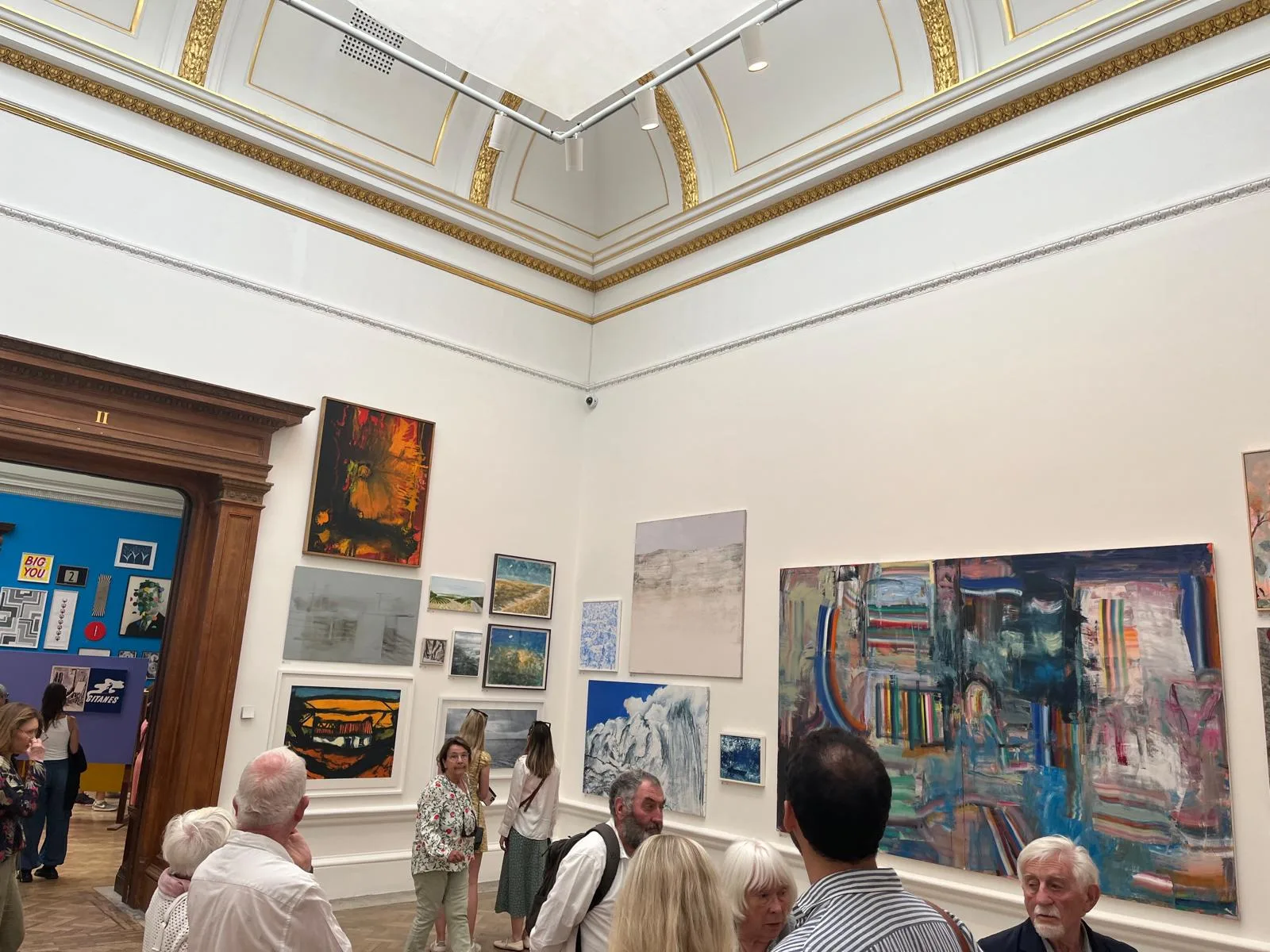 Gallery II at the Royal Academy of Arts during the Summer Exhibition 2024, its gilded ceiling and salon-style hang illustrating the scale of London's oldest open-submission art exhibition
