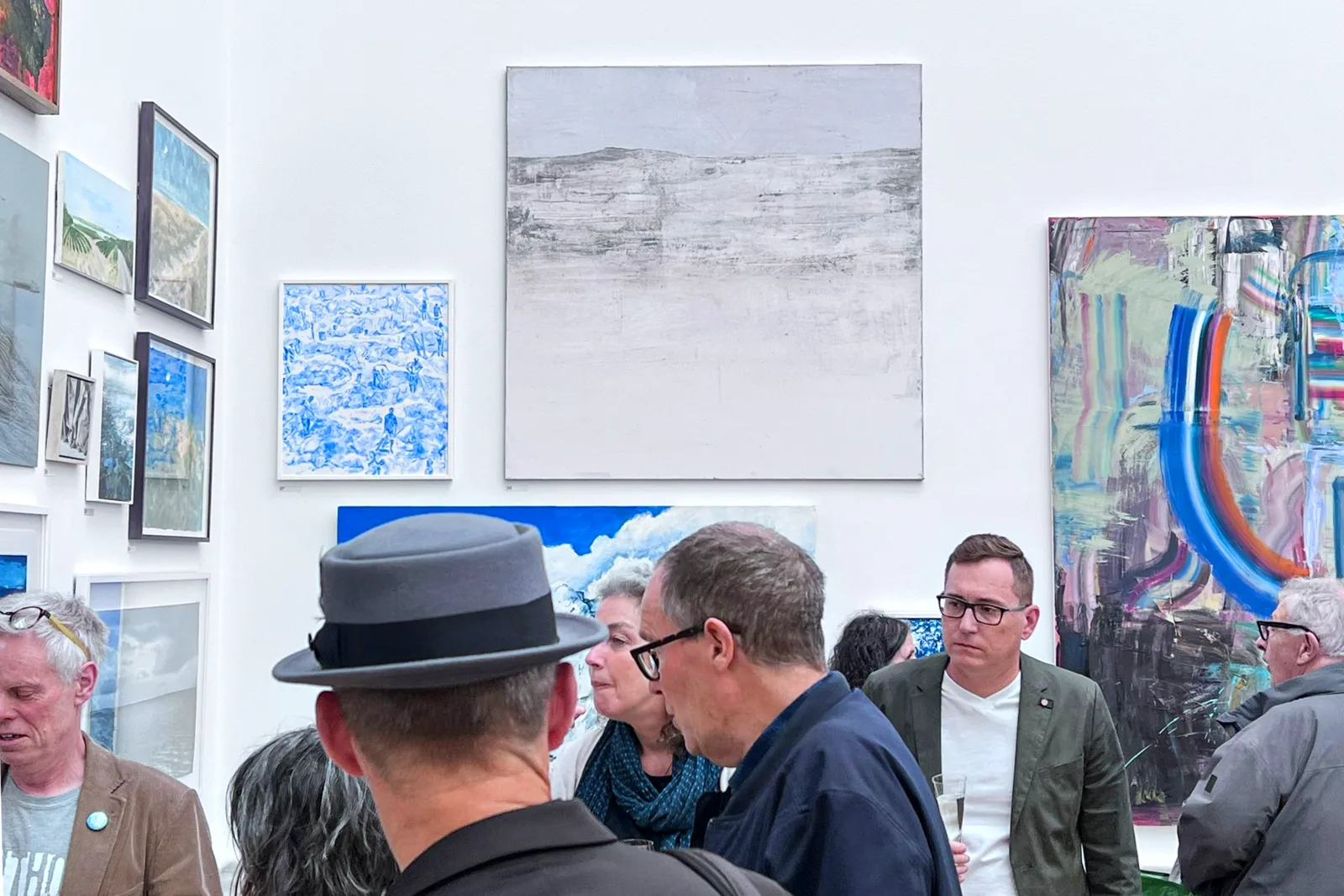 Visitors gathered in conversation in front of exhibited paintings during the Private View of the Royal Academy Summer Exhibition 2024, the evening my own painting found its collector