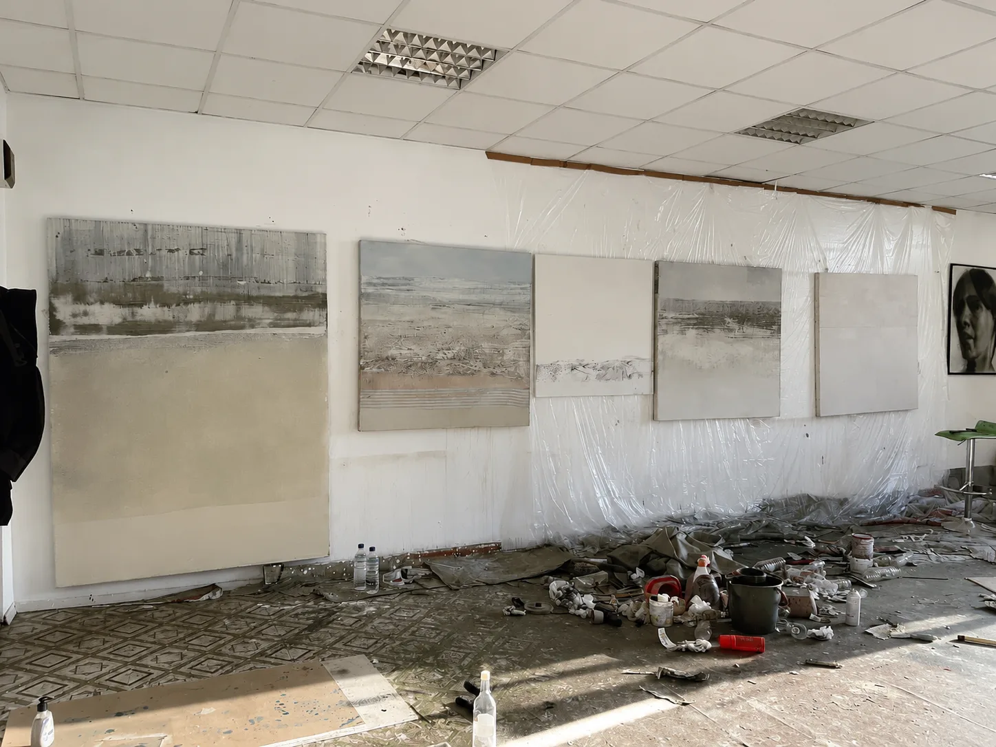 Five large-scale abstracted landscape paintings in progress, leaning against a studio wall side by side, showing how one body of work develops through repetition and variation